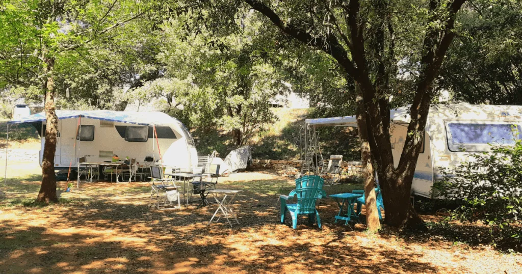 Emplacements ombragés pour caravanes au Camping de La Devèze, entourés d’arbres et équipés pour le confort.