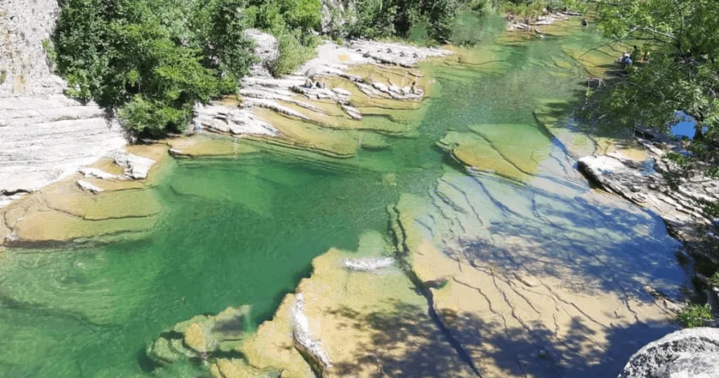 Vue apaisante de la rivière en aval de la Cascade de la Vis, un lieu idéal pour se détendre près du camping de la Devèze.